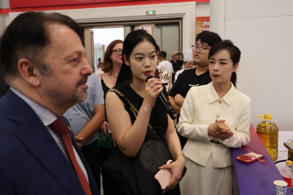 Luna announcing information to accordion guests in English